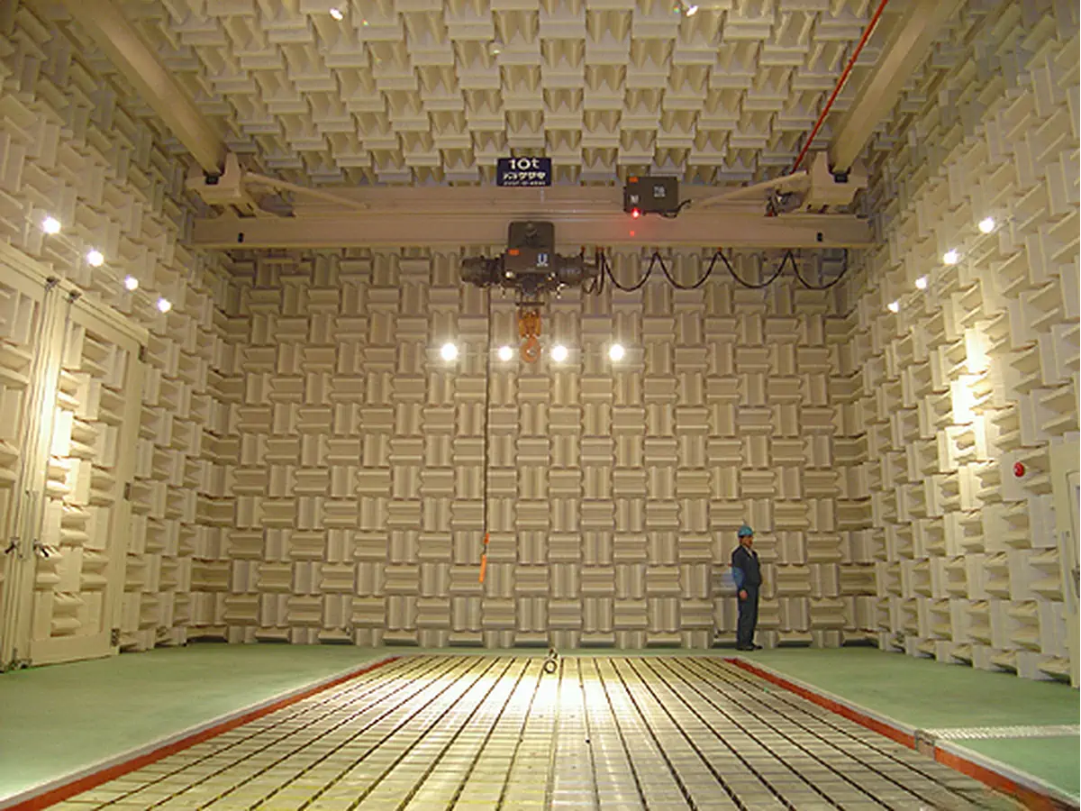 a person standing inside semi anechoic chamber showing a overhead indoor crane a person standing inside semi anechoic chamber showing a overhead indoor crane